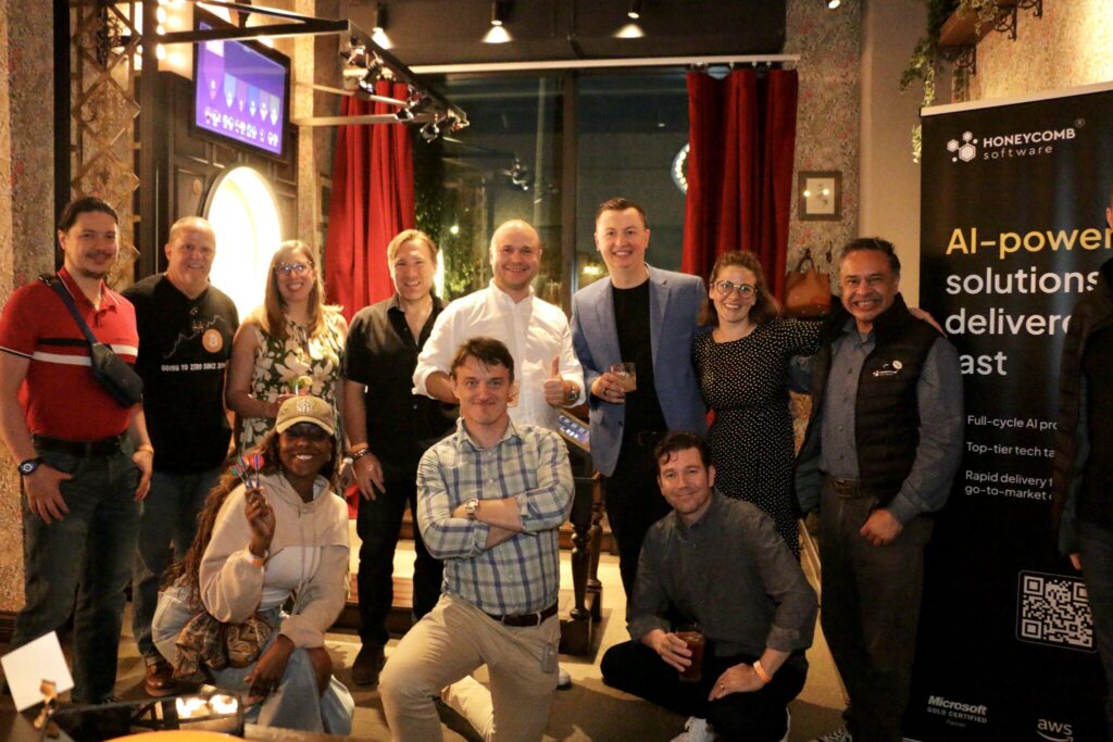 Group photo of attendees gathered at an evening Honeycomb Software celebration event